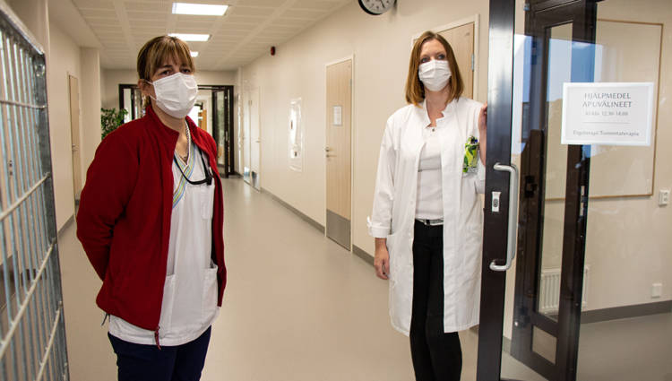 Osastonhoitaja Linda Ahlroos ja lääkäri Anna-Maria Sandberg seisovat valoisassa käytävässä.