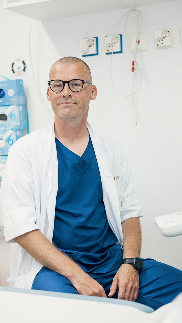 Patrik Ehnström, överläkare i urologi, sitter bredvid undersökningsbordet i mottagningsrummet.